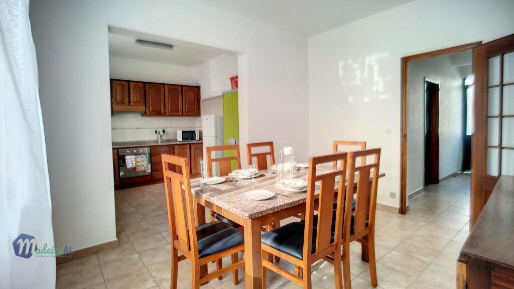 克鲁什港Casa do Romaninho的厨房以及带桌椅的用餐室。