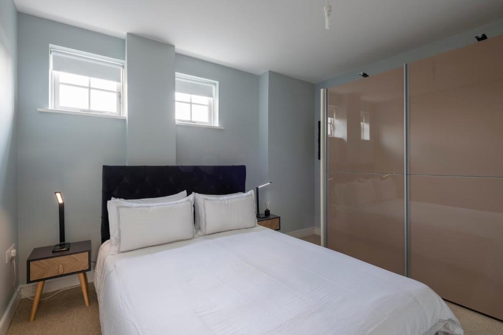 布伦特里Luxurious Private One Bedroom Apartment的卧室设有一张白色大床和两个窗户。