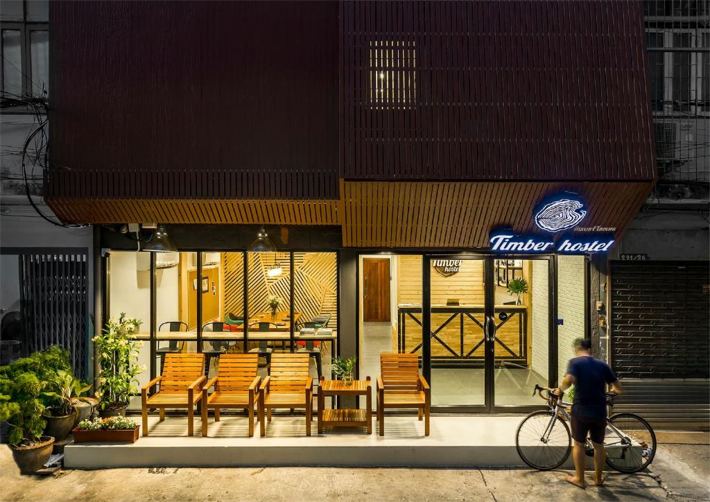 曼谷木材旅舍的一个人在餐馆前骑着自行车