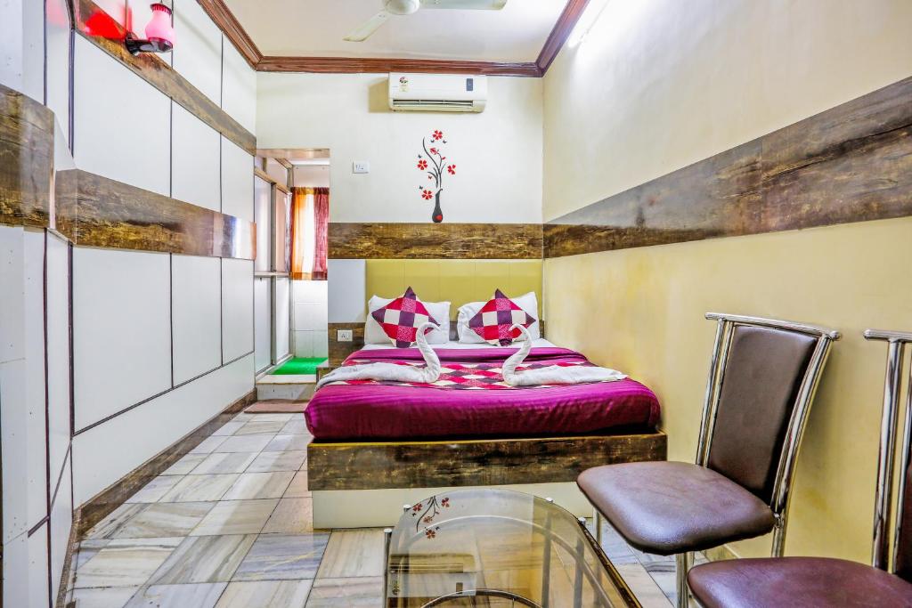 孟买HOTEL GOLDEN PLAZA的一间卧室配有一张床和两把椅子
