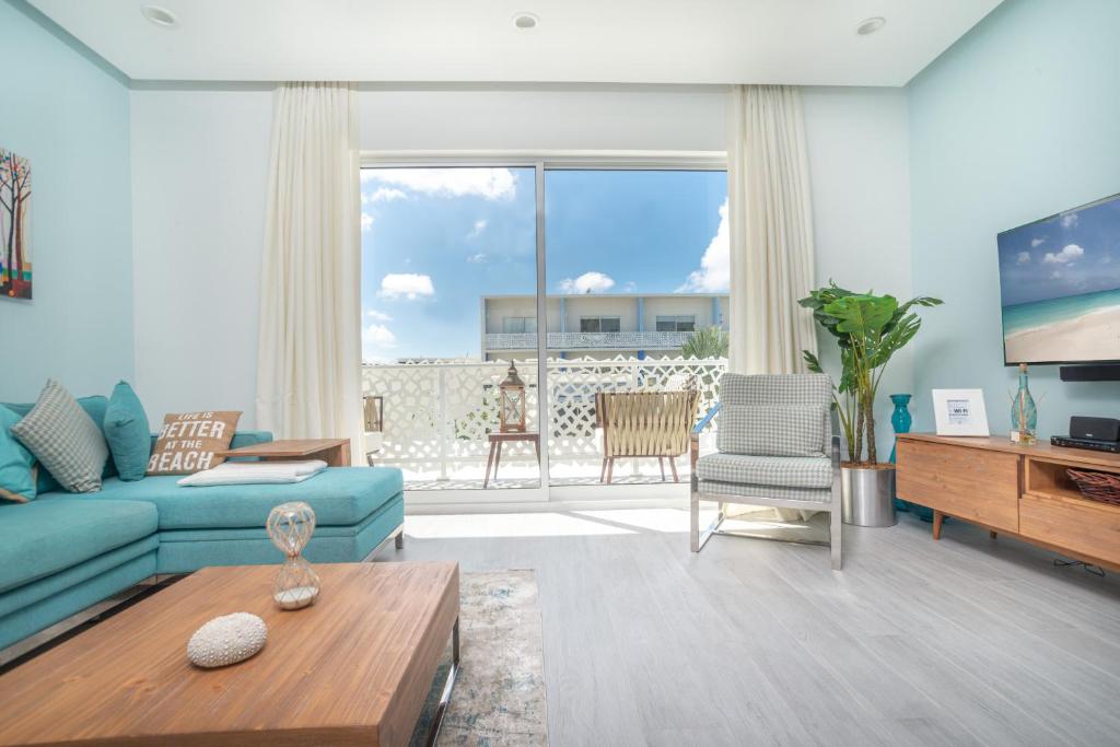 Upper LandLuxury 1 bed apartment near Seven Mile Beach at The Grove - Villa Caribbean Blues的客厅配有蓝色的沙发和桌子