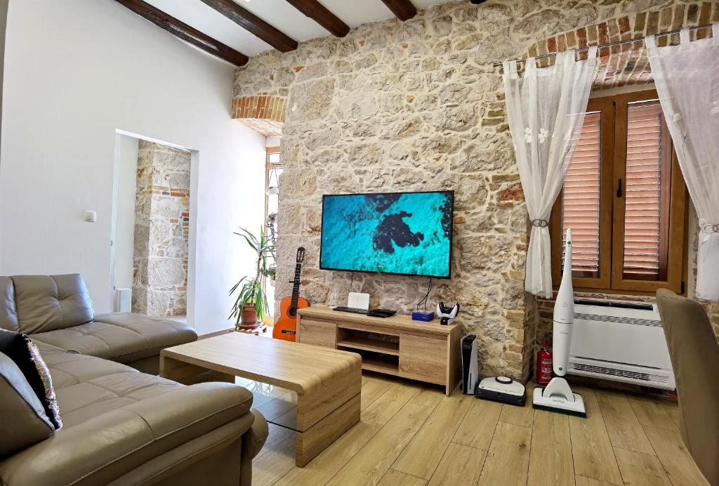 希贝尼克XY Suites - Design Apartments的带沙发和石墙的客厅