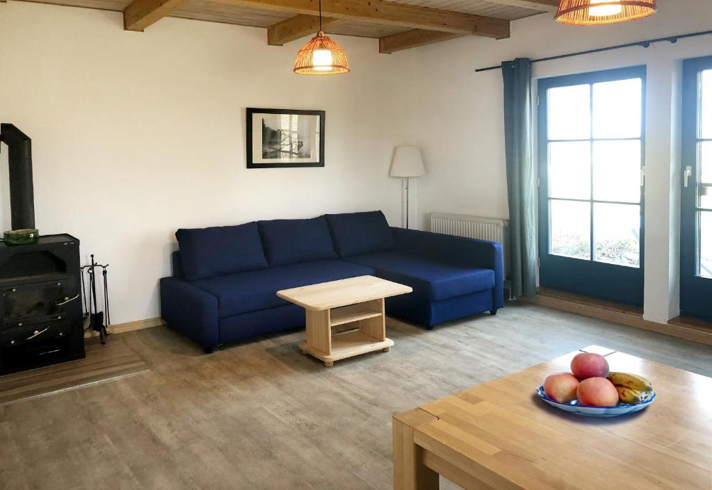 朗克维茨3-Raum Apartment bis 6 Pers 33的客厅配有蓝色的沙发和一碗水果