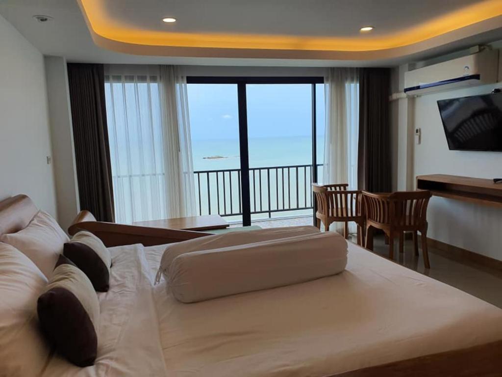 Ban PhalaGrace Seaview บ้านพักส่วนตัว 3 ห้องนอน วิวทะเล หาดพลา的酒店客房设有一张大床和一个阳台。