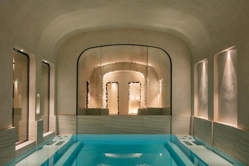 巴黎Pavillon Faubourg Saint-Germain & Spa的一个带大镜子的房间的游泳池