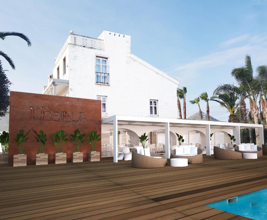 蒙德拉戈内Hotel & Resort Lunatenuta的 ⁇ 染带甲板的白色建筑