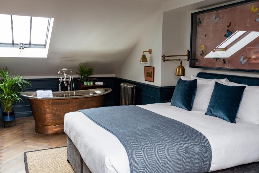 伦敦The Bull & Last的一间卧室配有一张床、一个浴缸和一个水槽