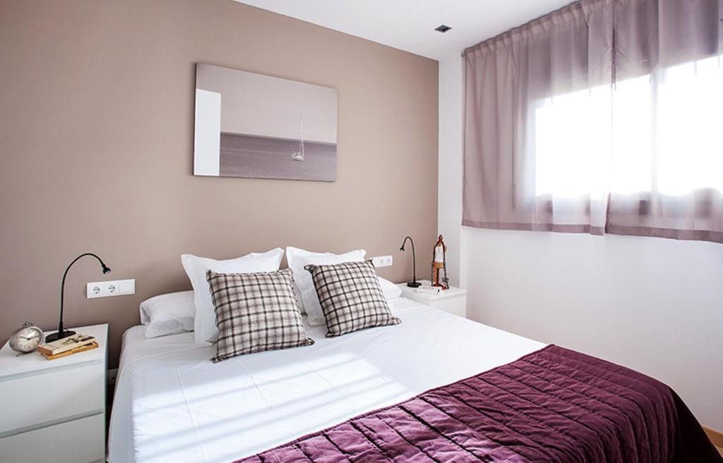 巴塞罗那杜莱特兰布拉玛公寓的卧室配有带枕头的白色床和窗户。