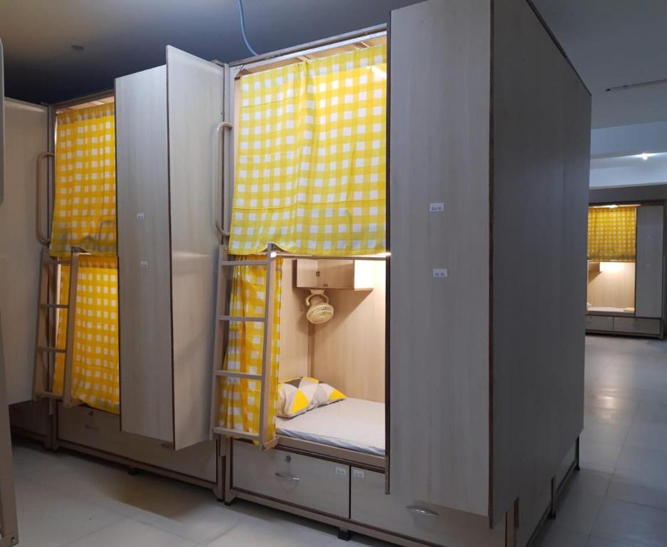 海得拉巴Abuzz OxfordCaps, Genome Valley Hyderabad的小房间设有一张带黄色窗帘的双层床