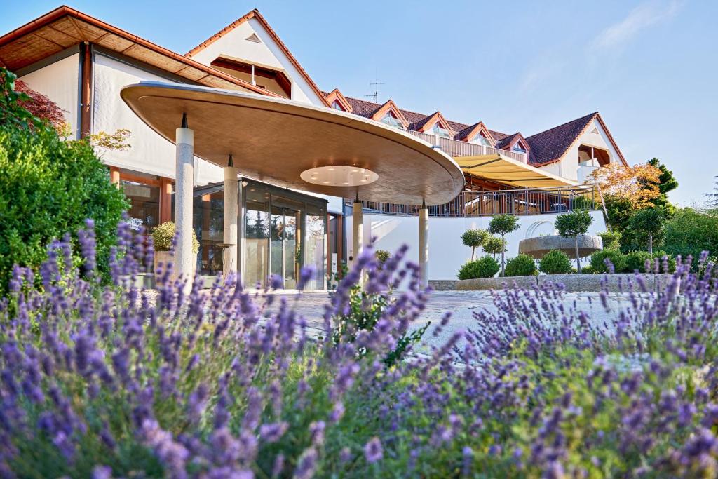 巴德瓦尔特斯多夫Ayurveda Resort MANDIRA的前面有紫色花的房屋