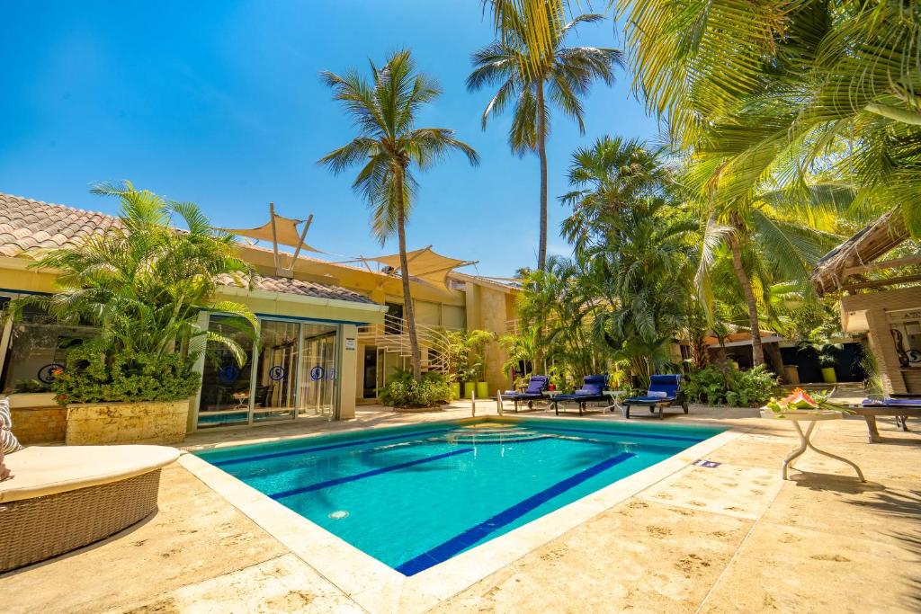 圣玛尔塔圣拓利尼精品酒店 的棕榈树屋前的游泳池