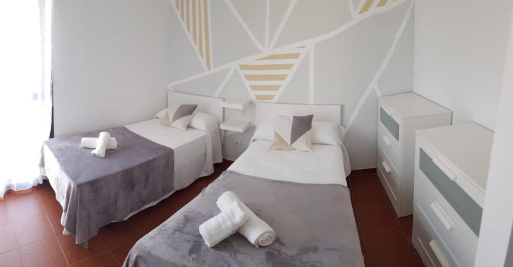 阿雷西费Casa Abian的白色的客房设有两张床和楼梯。