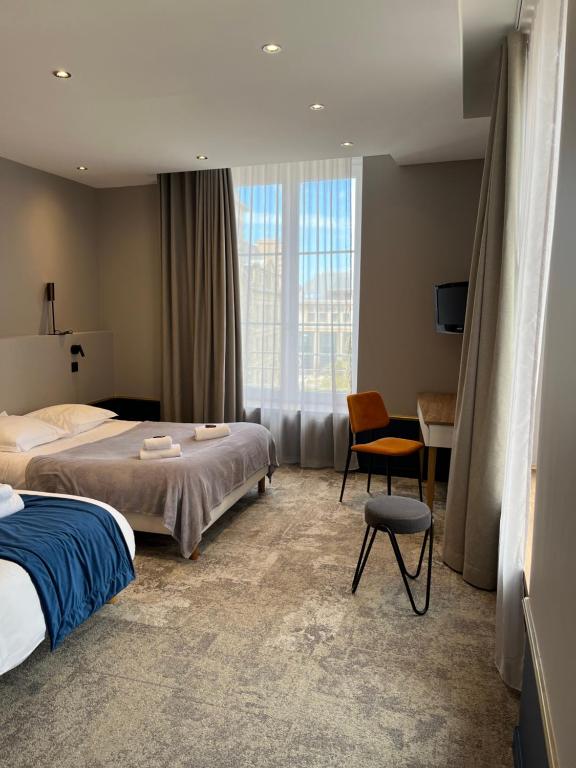 圣马洛Hotel Brasserie Armoricaine的配有一张床和一把椅子的酒店客房