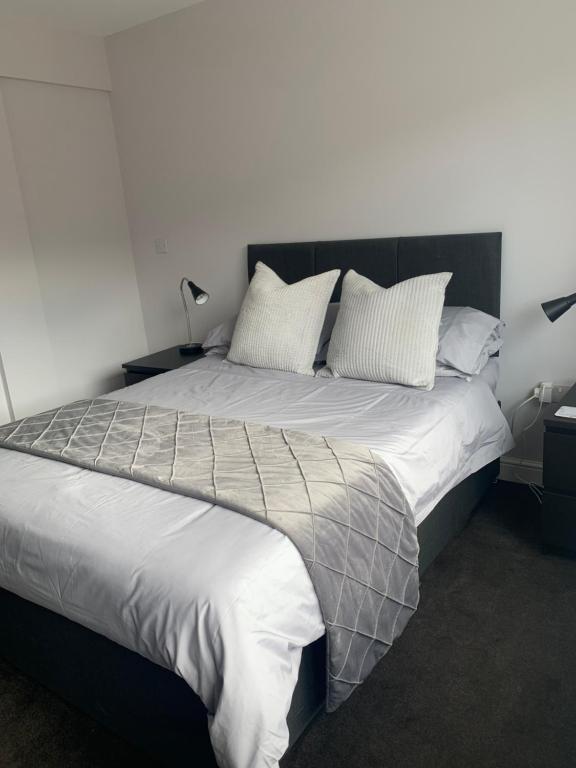 萨顿科尔菲尔德Sutton Park Lodge的卧室配有一张带白色床单和枕头的大床。
