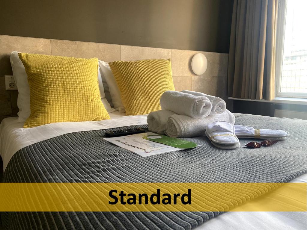 鹿特丹中央豪华酒店的床上有毛巾和鞋
