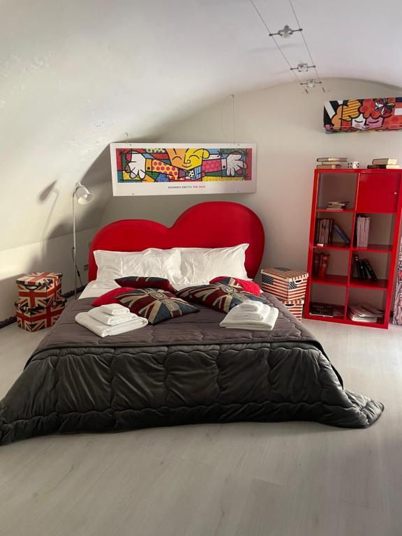 恩纳Loft P&G的一间卧室配有一张大床和红色床头板