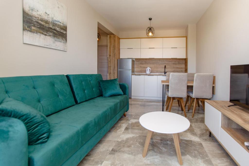 尤塔哈Posejdon Lux的一间带绿色沙发的客厅和一间厨房
