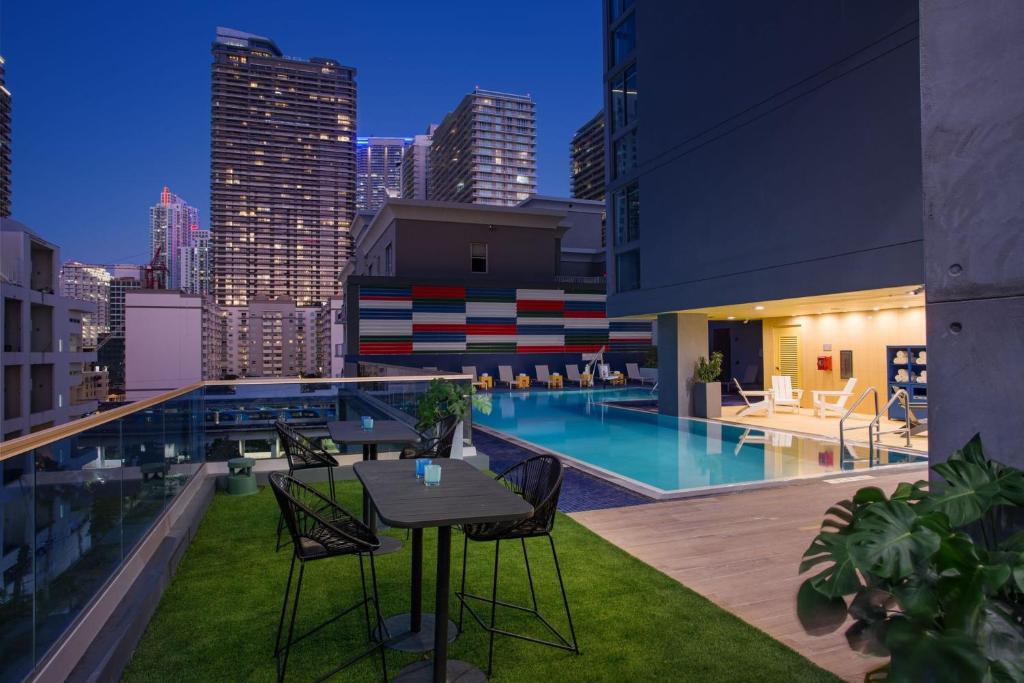 迈阿密Atwell Suites - Miami Brickell, an IHG Hotel的一个带桌椅的屋顶露台和一个游泳池
