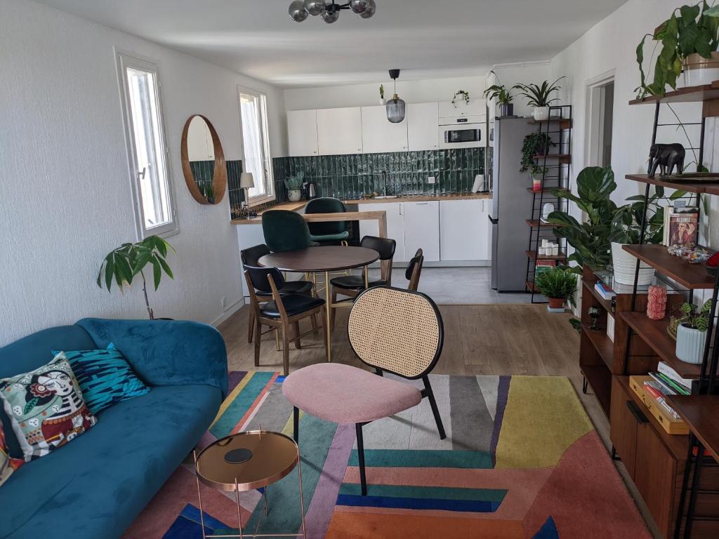 Le Pré-Saint-GervaisAppartement 3 pièces avec parking couvert gratuit.的一间带蓝色沙发的客厅和一间厨房