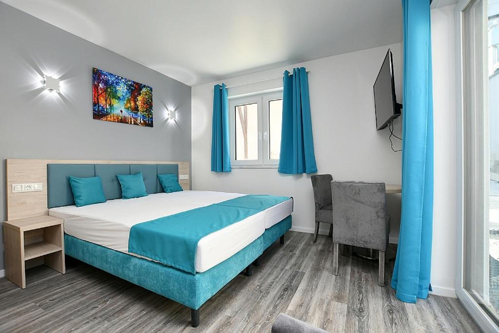 斯图加特City-Hotel Zuffenhausen的一间卧室配有一张床、一张书桌和一台电视。