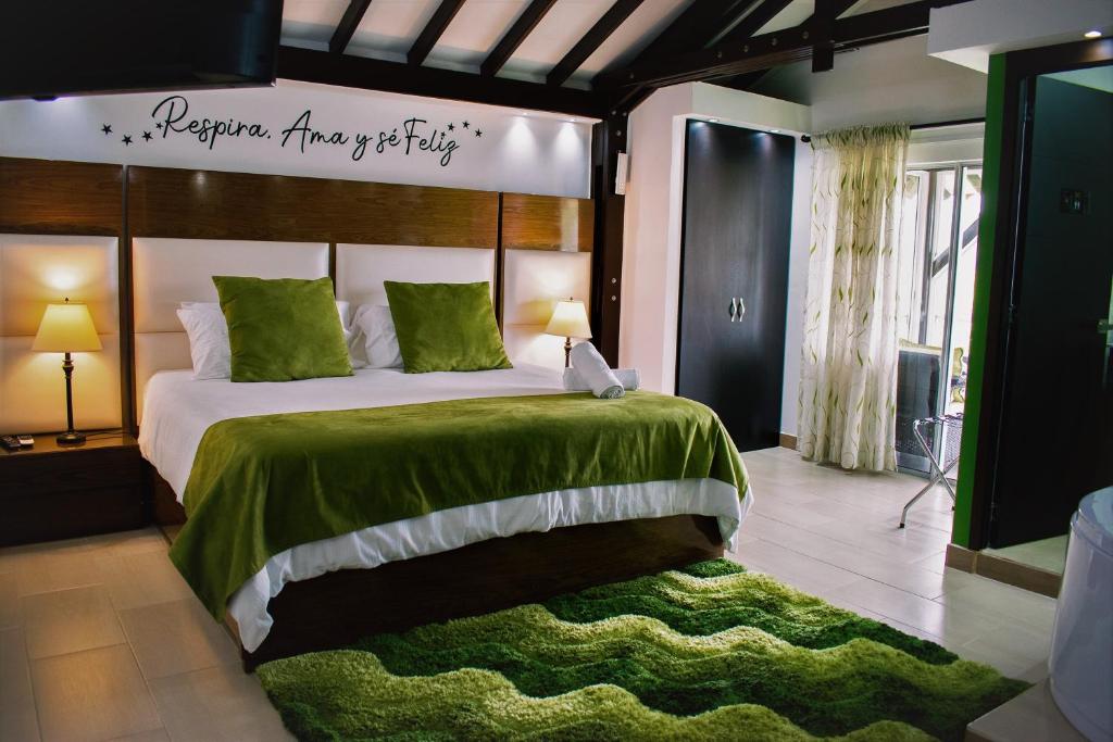 圣罗莎德卡瓦尔Hotel Jade Spa的一间卧室配有一张带绿毯的大床