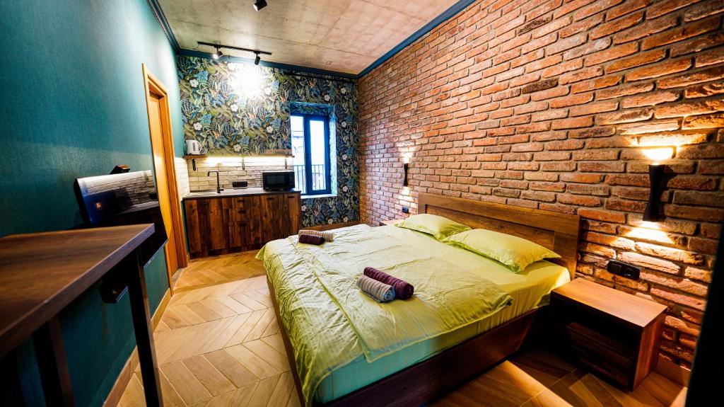 第比利斯Anbani Apartments - City Center的一间卧室设有一张床和砖墙