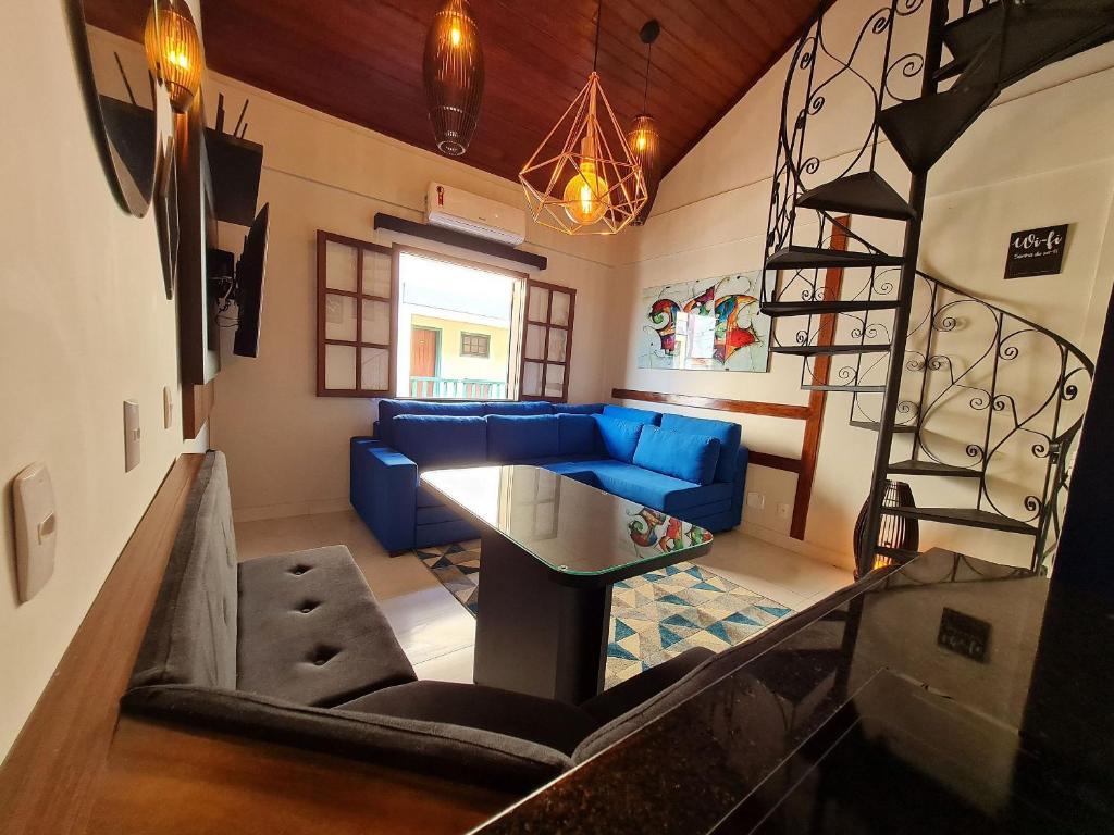 卡波布里奥Apto Duplex, Peró - Cabo Frio. Conforto, Piscina, Beira Mar.的客厅设有蓝色的沙发和楼梯。