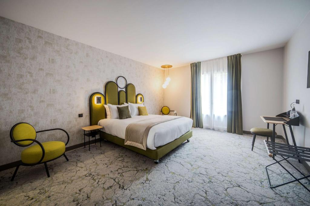 韦尔蒂Best Western Le Relais du Vigneron的一间卧室配有一张大床和大床头板