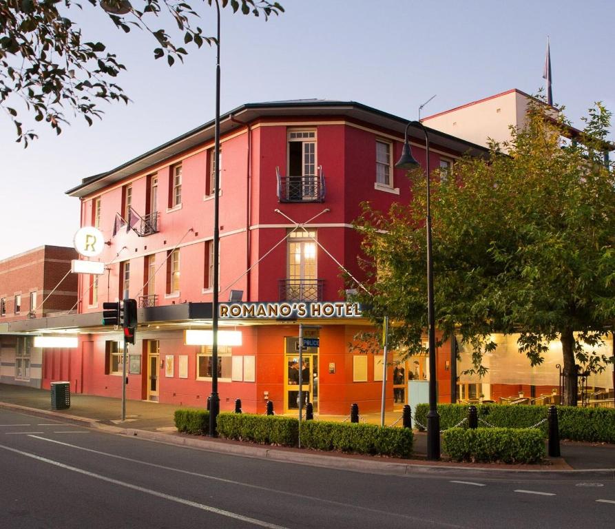 沃加沃加Romano's Hotel & Suites Wagga Wagga的街道拐角处的红色建筑
