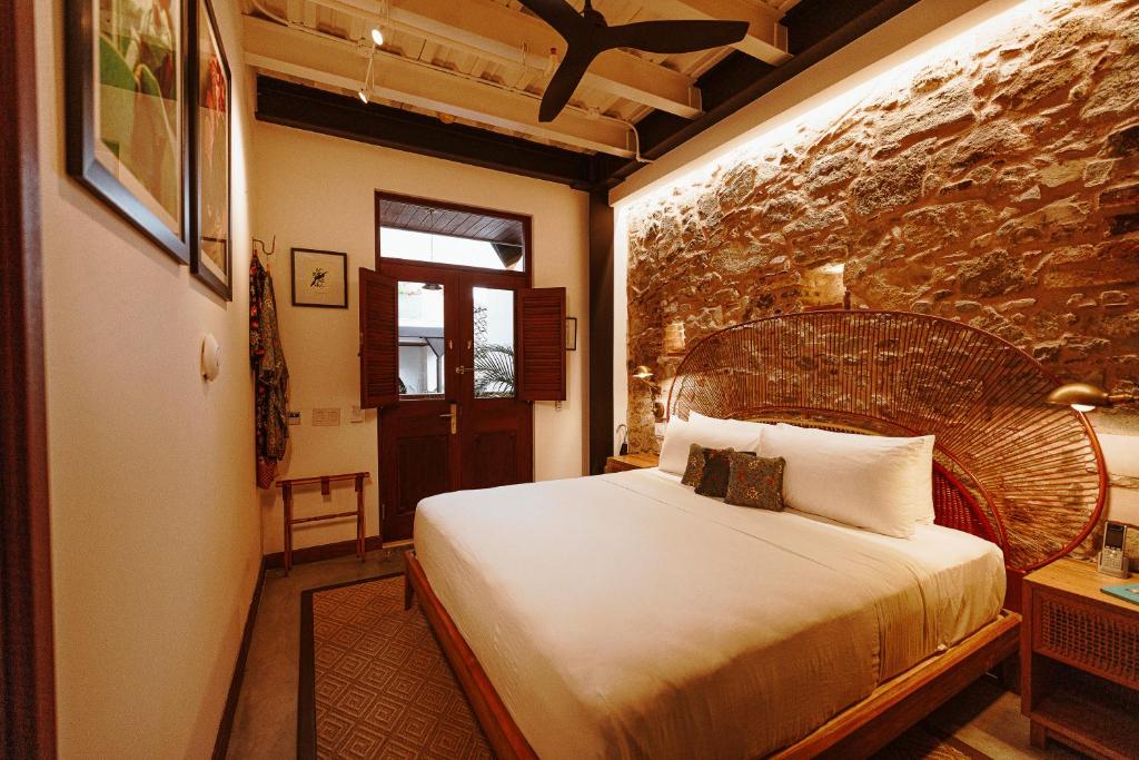 巴拿马城Amarla Boutique Hotel Casco Viejo的一间卧室设有一张大床和石墙