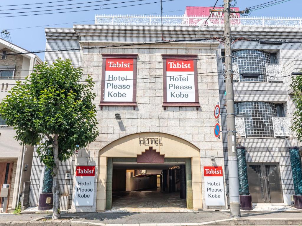 神户Tabist Hotel Please Kobe的前面有拱门的砖砌建筑