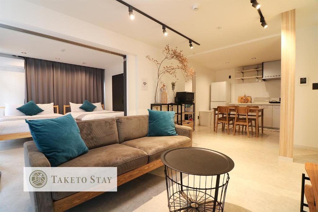 札幌TAKETO STAY Sumikawa House的带沙发的客厅和用餐室