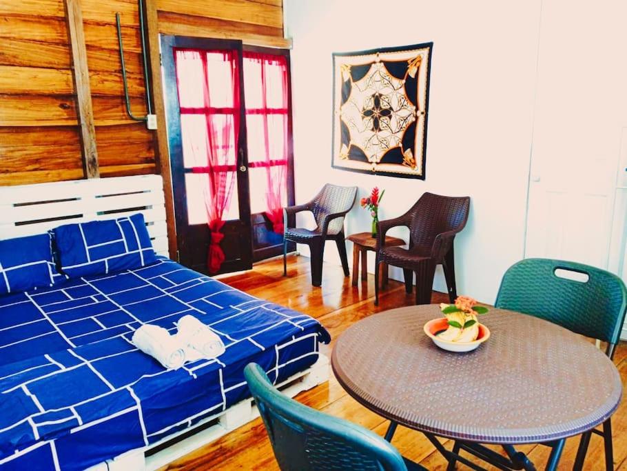 博卡斯德尔托罗Poetry Garden Bocas Town Colon Island- Deluxe Bungalow Cabin-AC-Enjoy the Night Life的卧室配有一张床和一张桌子及椅子