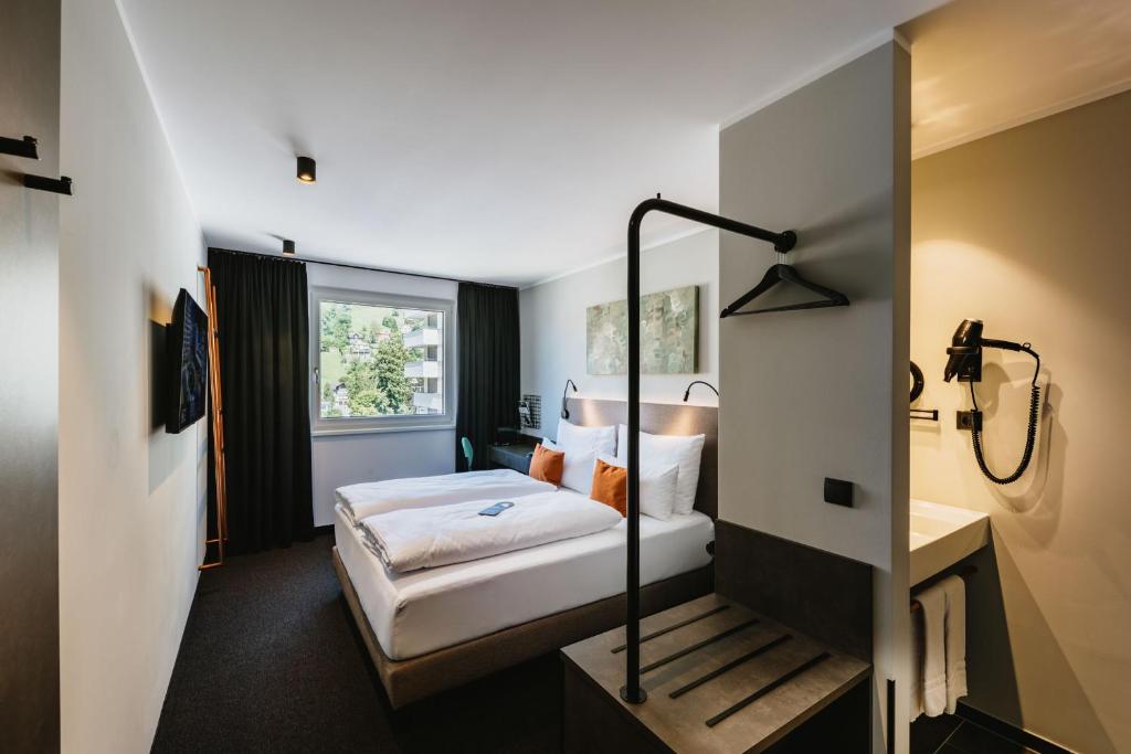 费尔德基希NIGHT INN Hotel Bahnhofcity Feldkirch的一间酒店客房 - 带一张床和一间浴室
