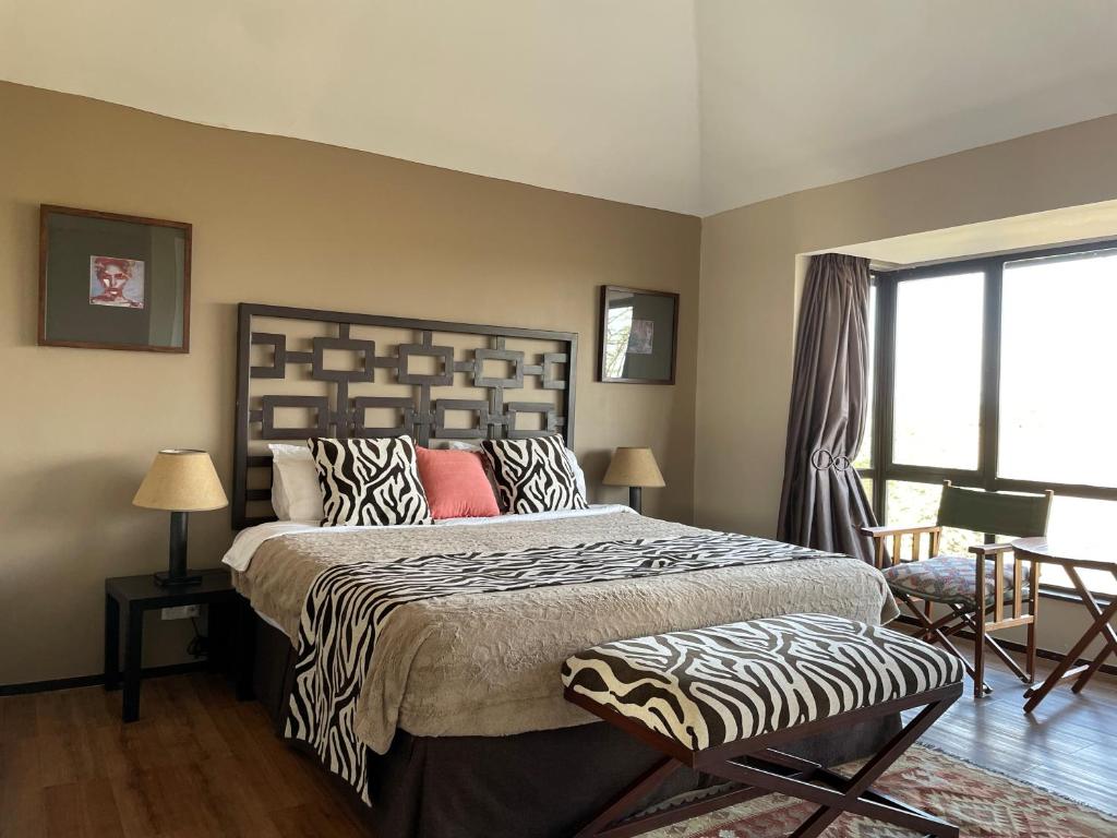 纳纽基Nyikani Villa Olpejeta的一间卧室配有一张大床和斑马图案床头板