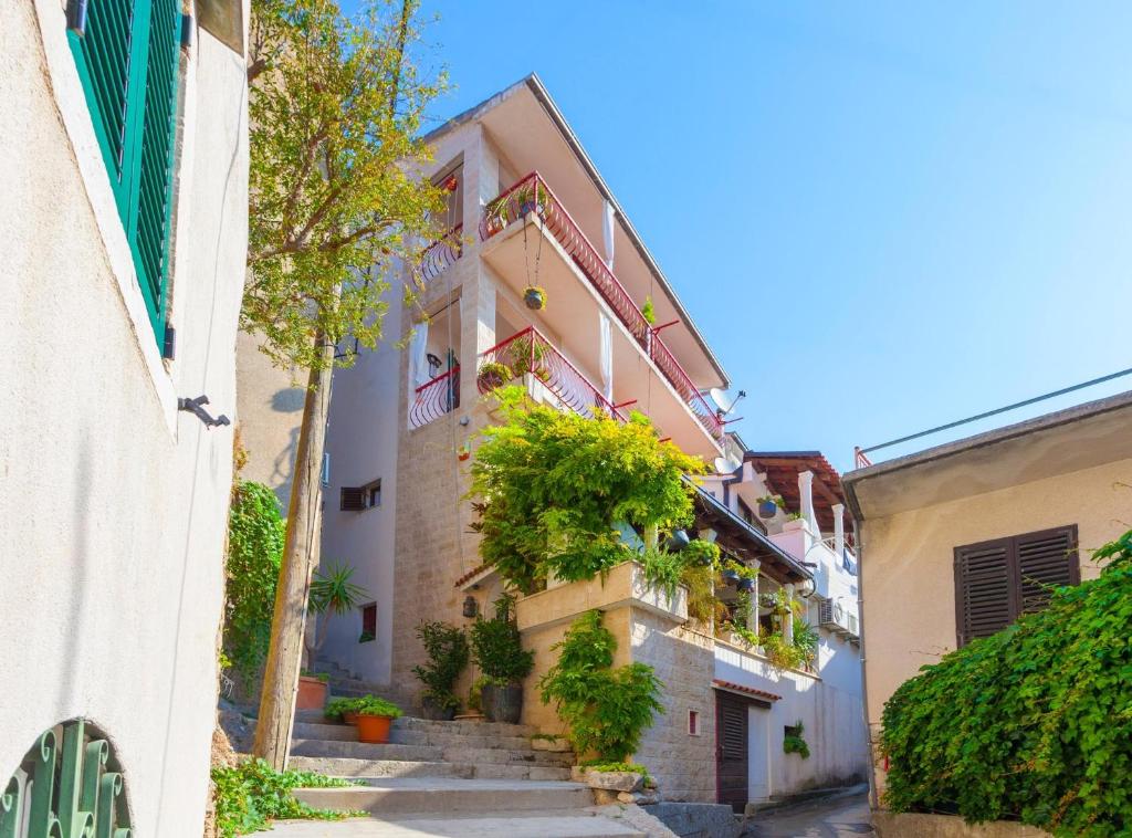 马卡尔斯卡Apartments and rooms with WiFi Makarska - 11063的楼里种有楼梯和植物的小巷