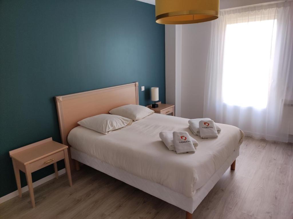 阿朗松多米提里斯花园旅馆的一间卧室配有一张床,上面有两条毛巾