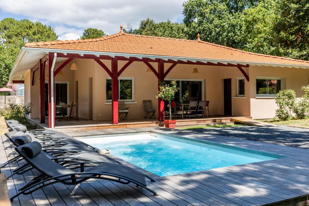 朗通Villa Tilé Lanton的一座带游泳池和凉亭的房子