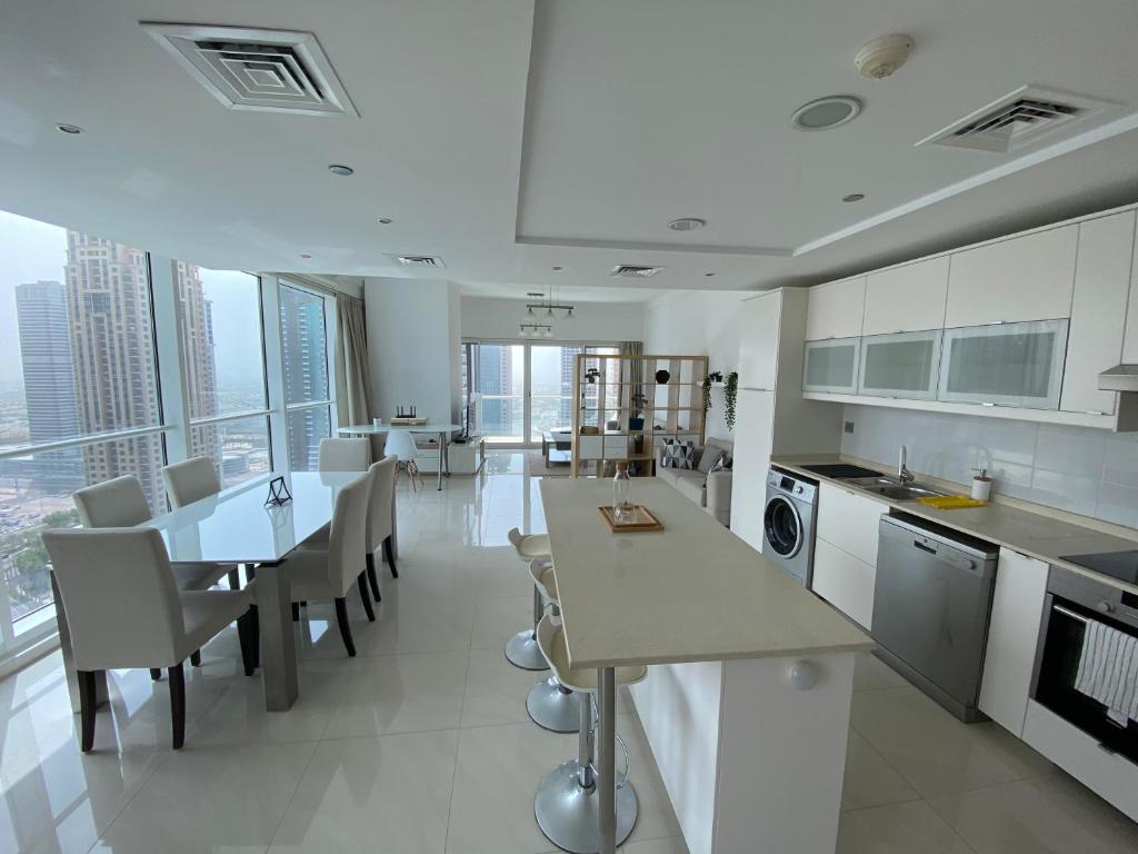 迪拜One bedroom apartment with pool & gym near Marina的一间带桌椅的厨房和一间用餐室