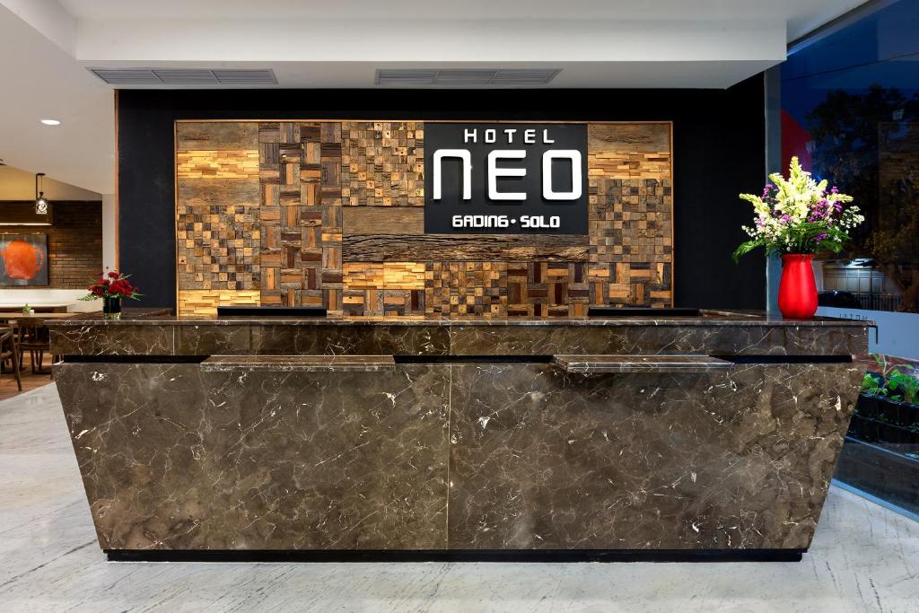 梭罗Hotel Neo Gading Solo的酒店大堂,墙上挂着酒店的新标志