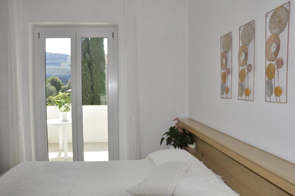 加尔达湖滨Appartamento Alba的一间白色卧室,配有床和阳台