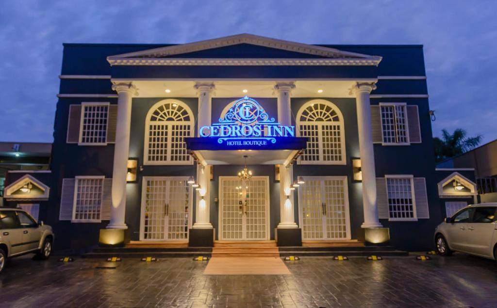 瓜亚基尔Cedros Inn Boutique Hotel的蓝色的建筑,上面标有第一个旅馆