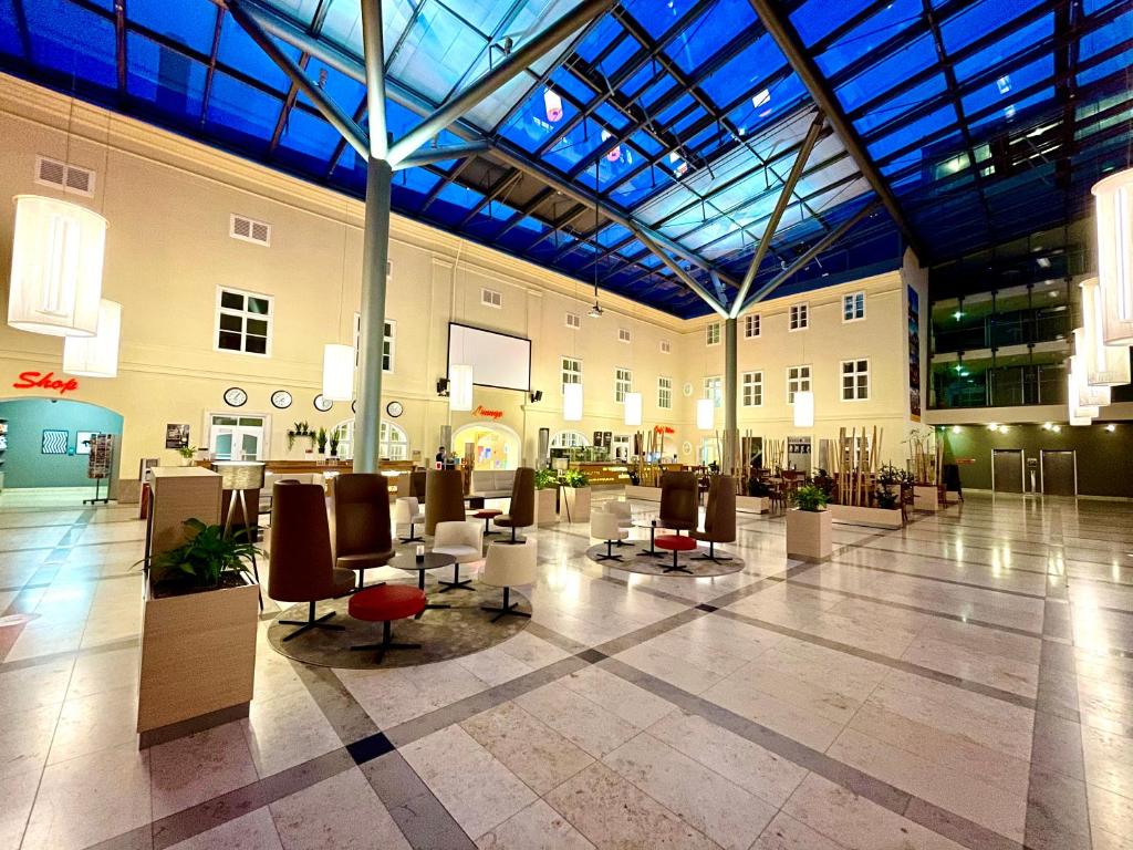 维也纳JUFA Hotel Wien City的大楼内带桌椅的大型大堂