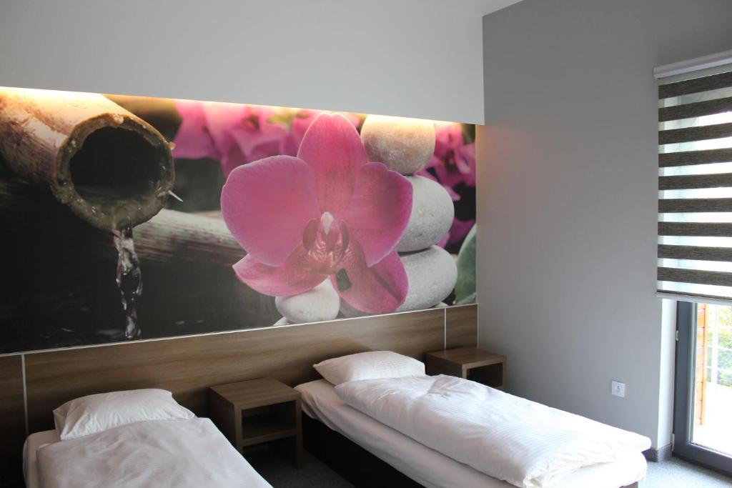 希隆斯克地区沃济斯瓦夫Jordaszka的一间设有两张床的房间和一幅花画