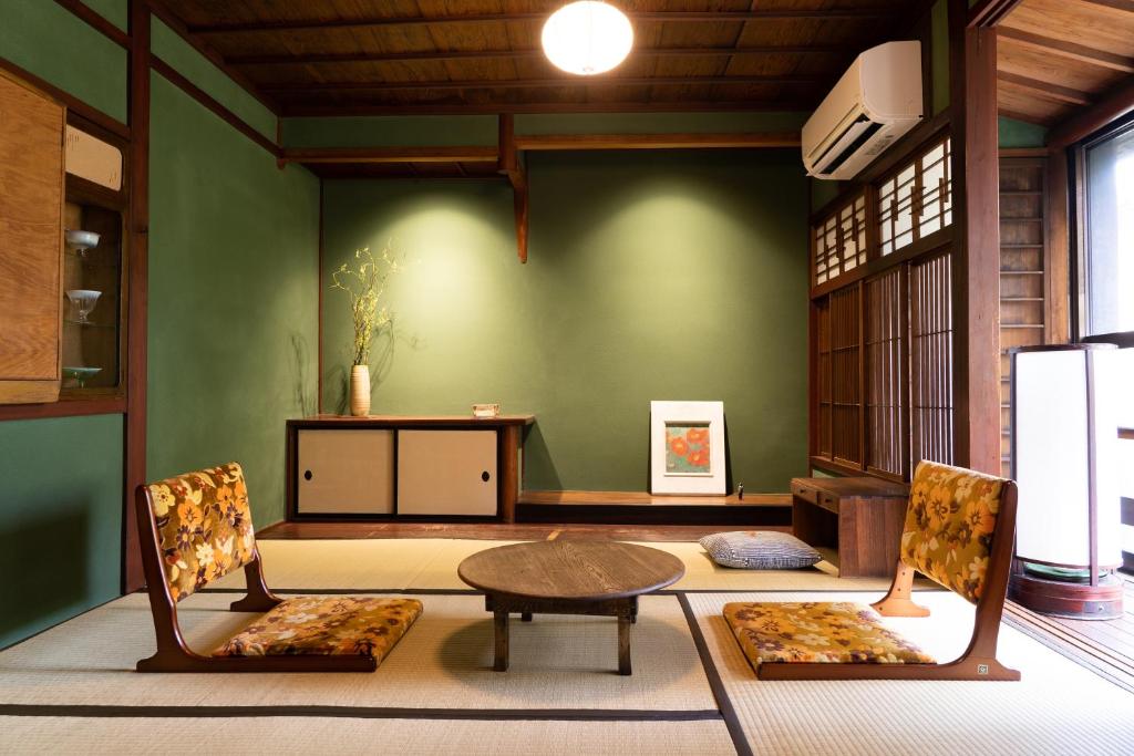 金泽Machiya Guest House Carta的一间设有两把椅子、一张桌子和一张桌子的房间