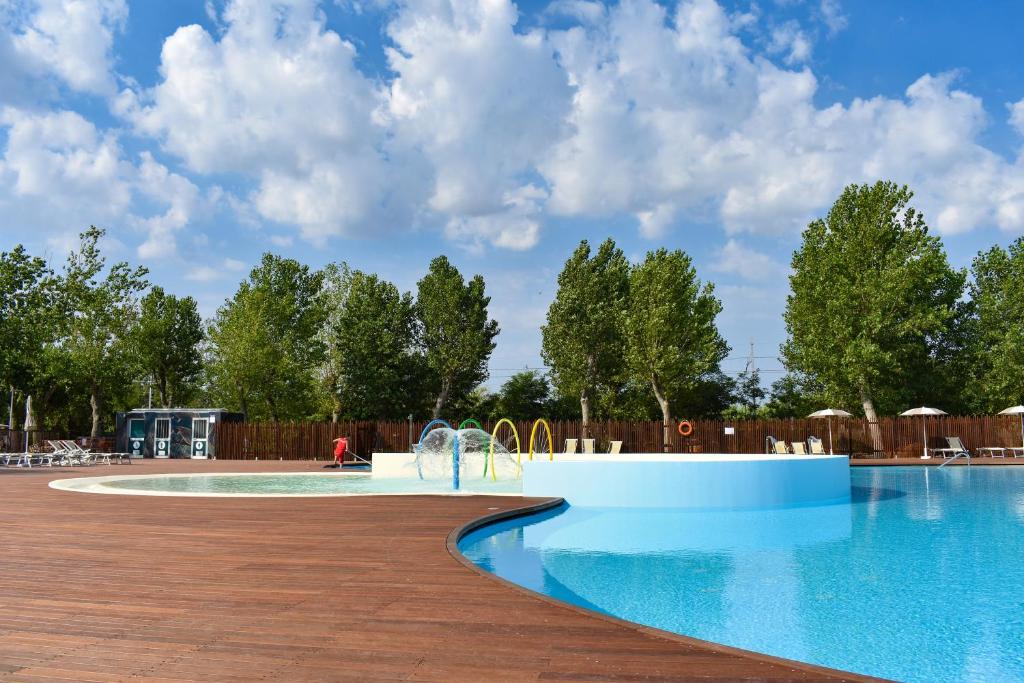 里米尼Rimini Family Village的度假村的游泳池,设有木栅栏