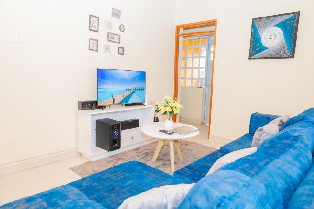 尼耶利The Stay Comfort的客厅配有蓝色的沙发和电视