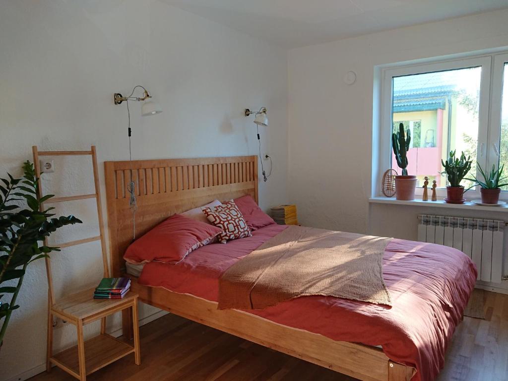 珀尔瓦Õdus korter roheluses - A cozy apartment in a greenery - contactless check-in的一间卧室配有一张带红色床单的床和一扇窗户。