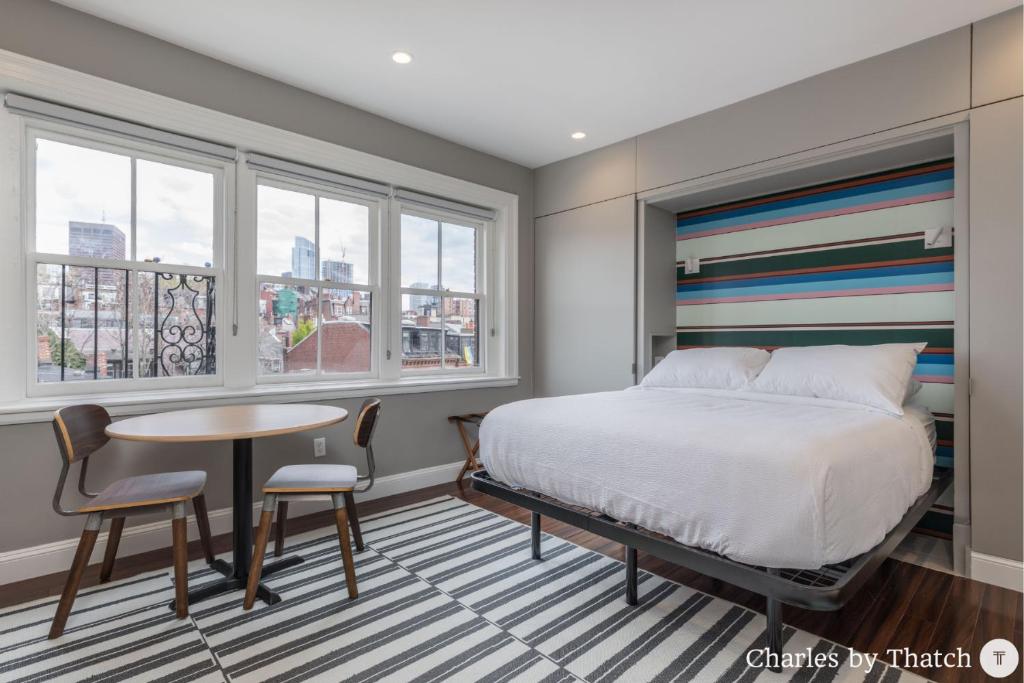 波士顿94 Charles Street by Thatch的卧室配有床、桌子和窗户。