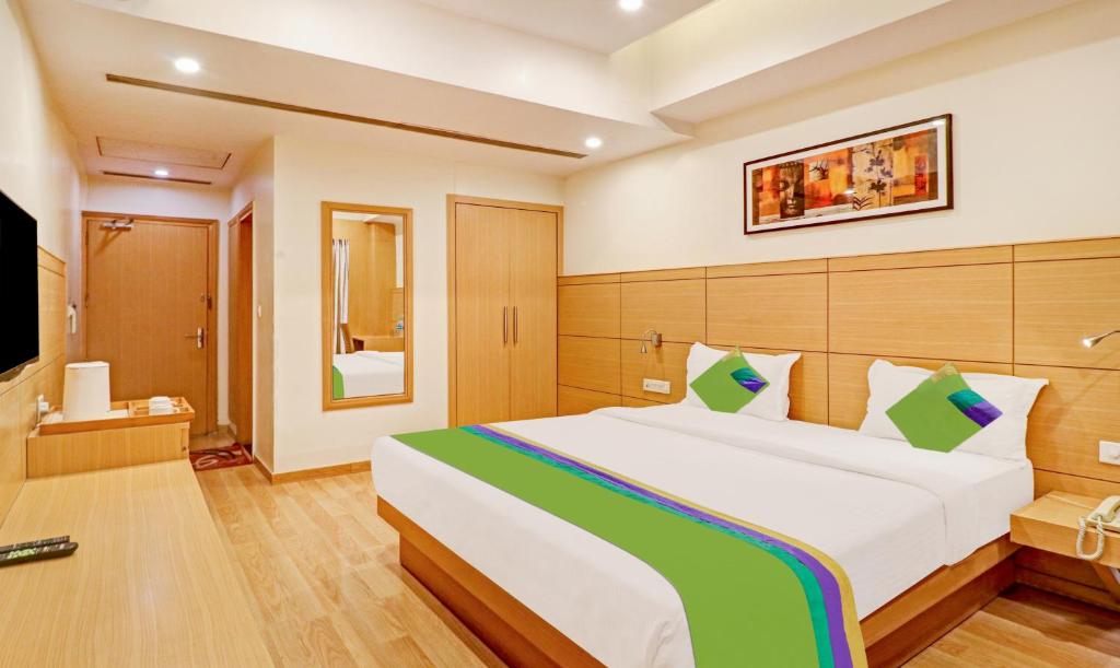 新德里Treebo Trend Galaxy Rooms的一间卧室配有一张大床和电视